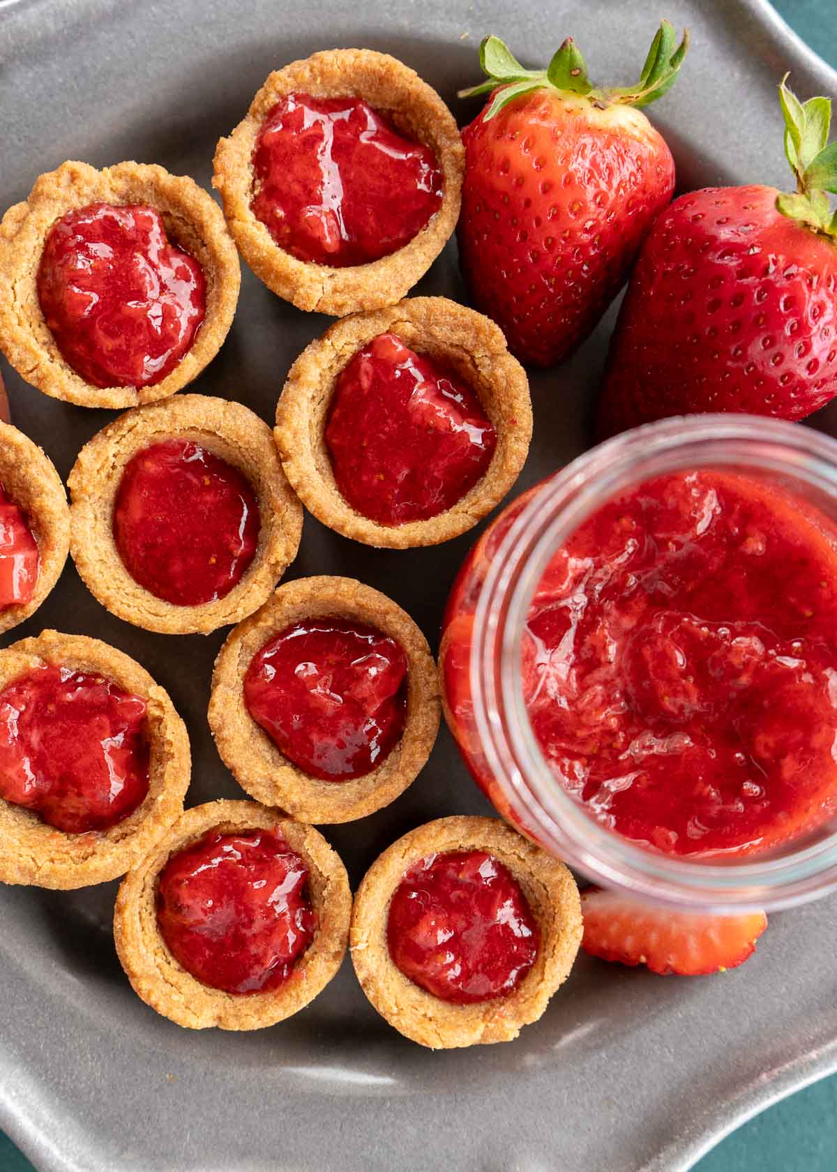 peanut butter cookie cups filled with strawberry sauce for peanut butter and jelly cookie cups