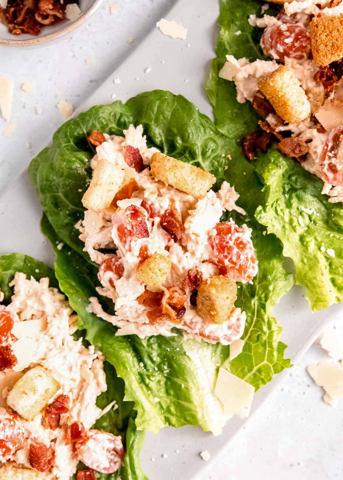 overhead image of chicken caesar salad lettuce wrap on white cutting board