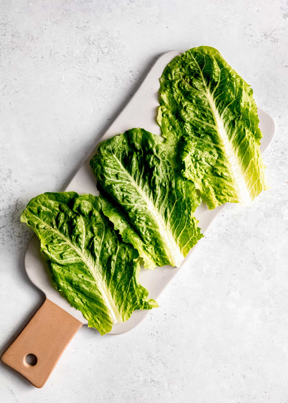 lettuce leaves on a white cutting obard