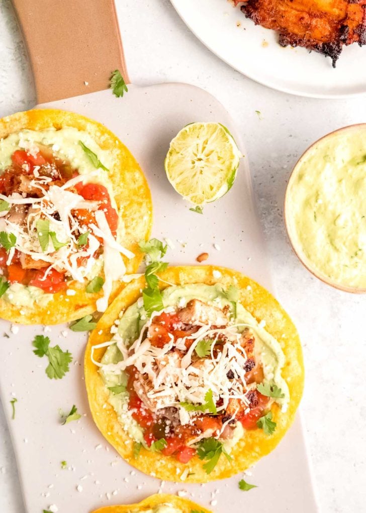 overhead image of two grilled chicken tacos on a cutting board