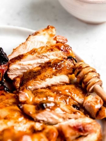 sliced honey mustard chicken on a white plate