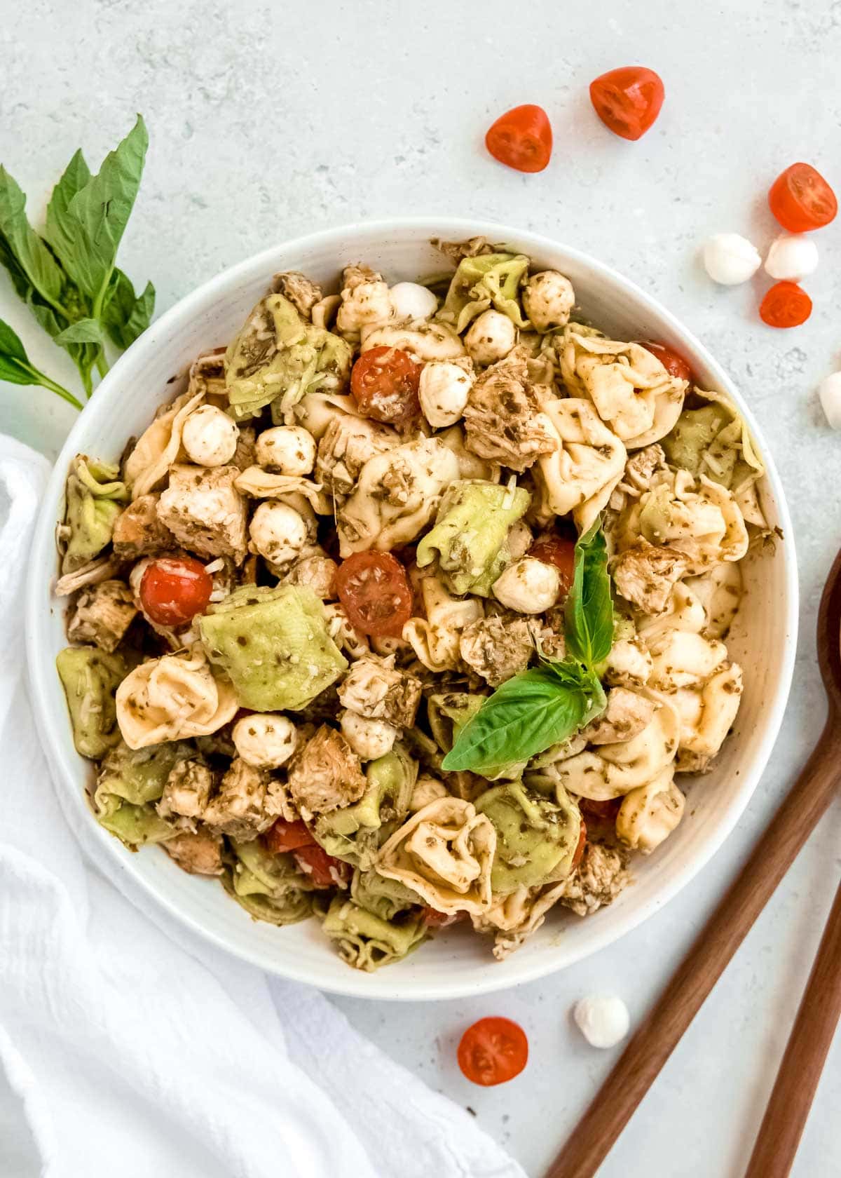 overhead image of tortellini pasta salad on white table with fork