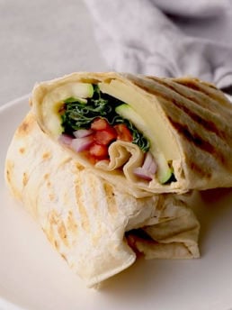 A veggie wrap on a white plate
