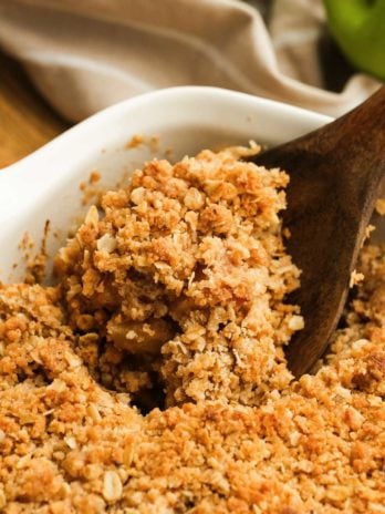 close up image of a wooden spoon and apple crisp
