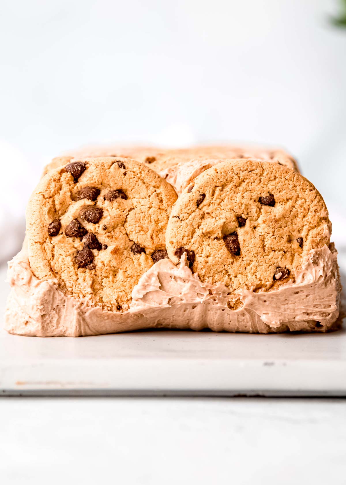 side view showing chocolate chip cookies on the end of the frozen mocha cake