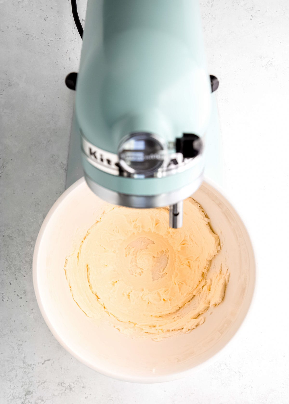 butter being creamed in a stand mixer to make buttercream frosting