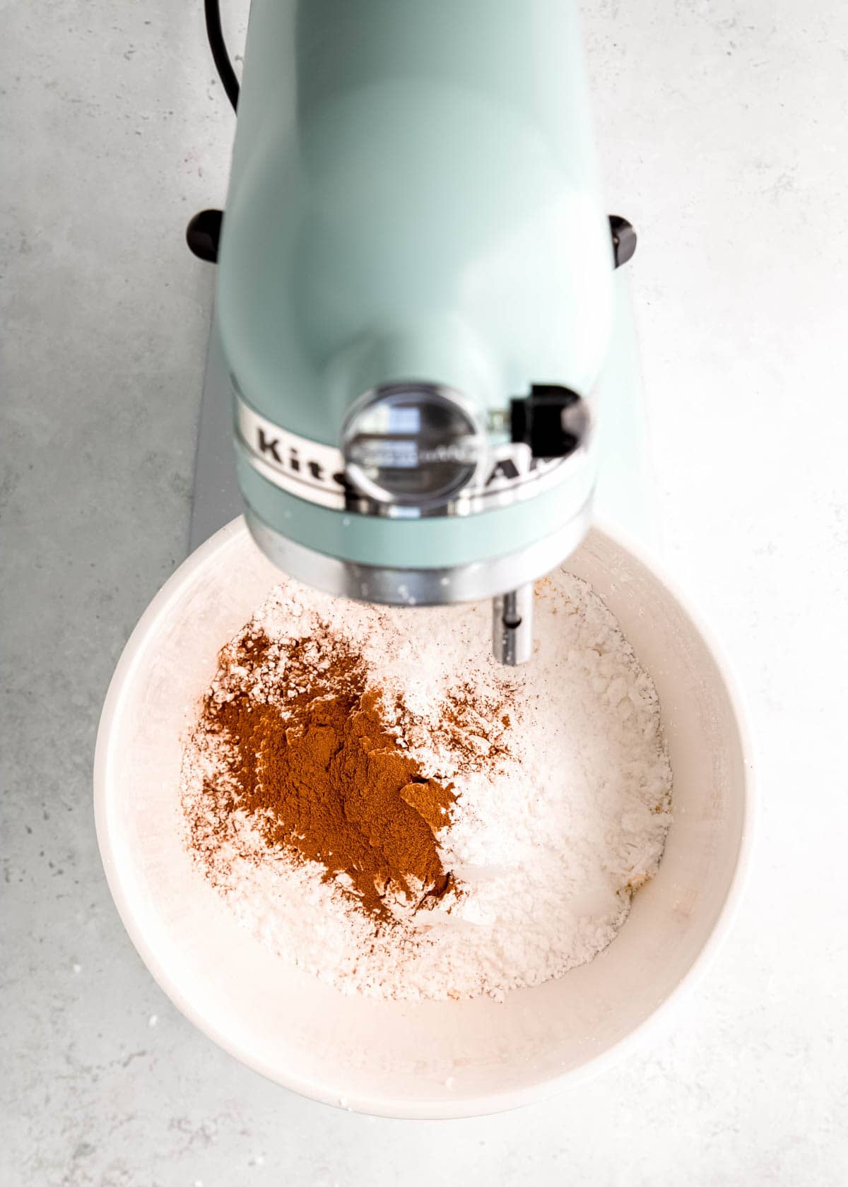 cinnamon and powdered sugar added to stand mixer to create cinnamon buttercream frosting