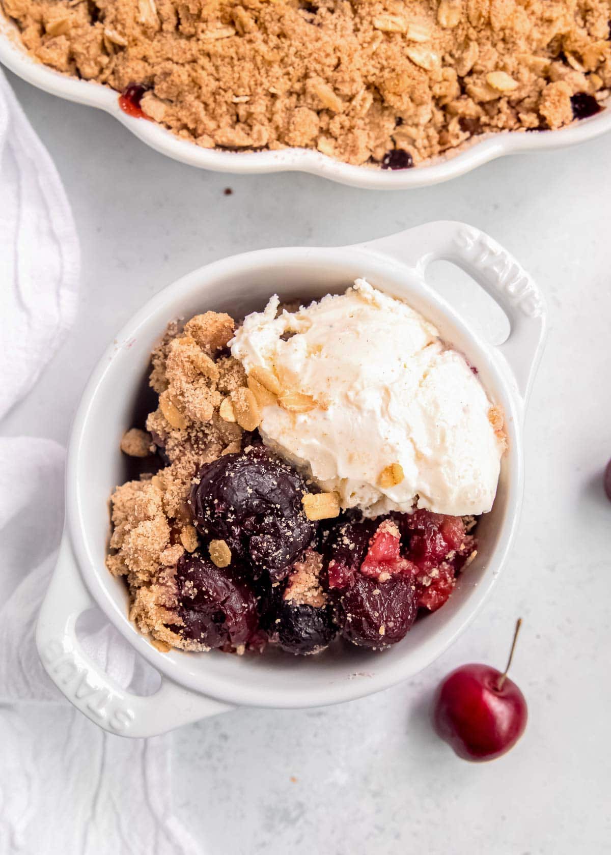 a bowl filled with the perfect cherry crisp and vanilla ice cream