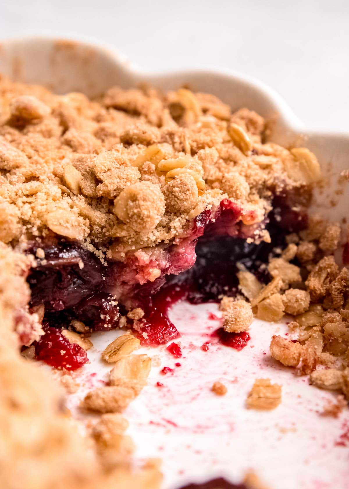 closeup shot showing the gooey cherry crisp filling under a crumbly brown sugar and oat topping
