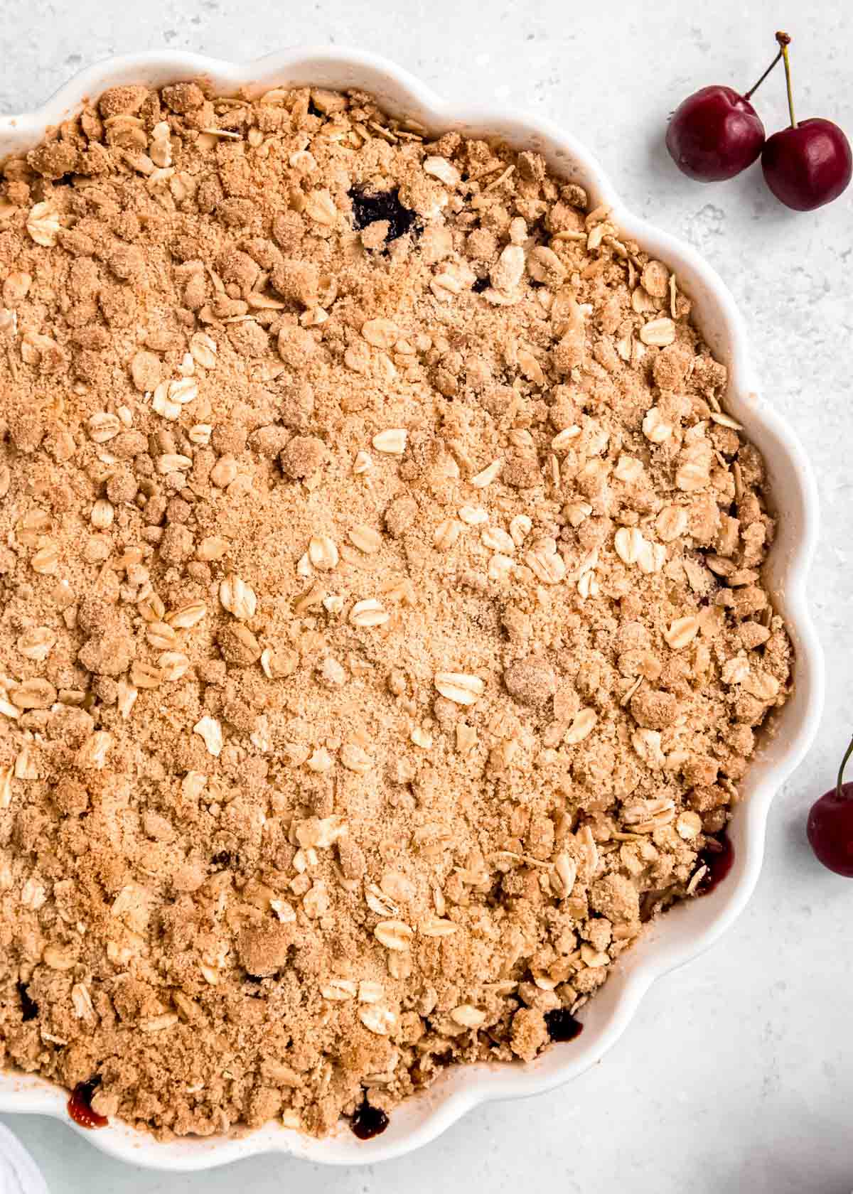closeup of a baked cherry crisp with a golden brown oat topping