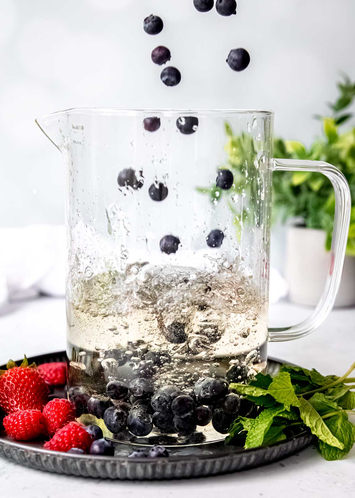 berries being poured into a sangria pitcher