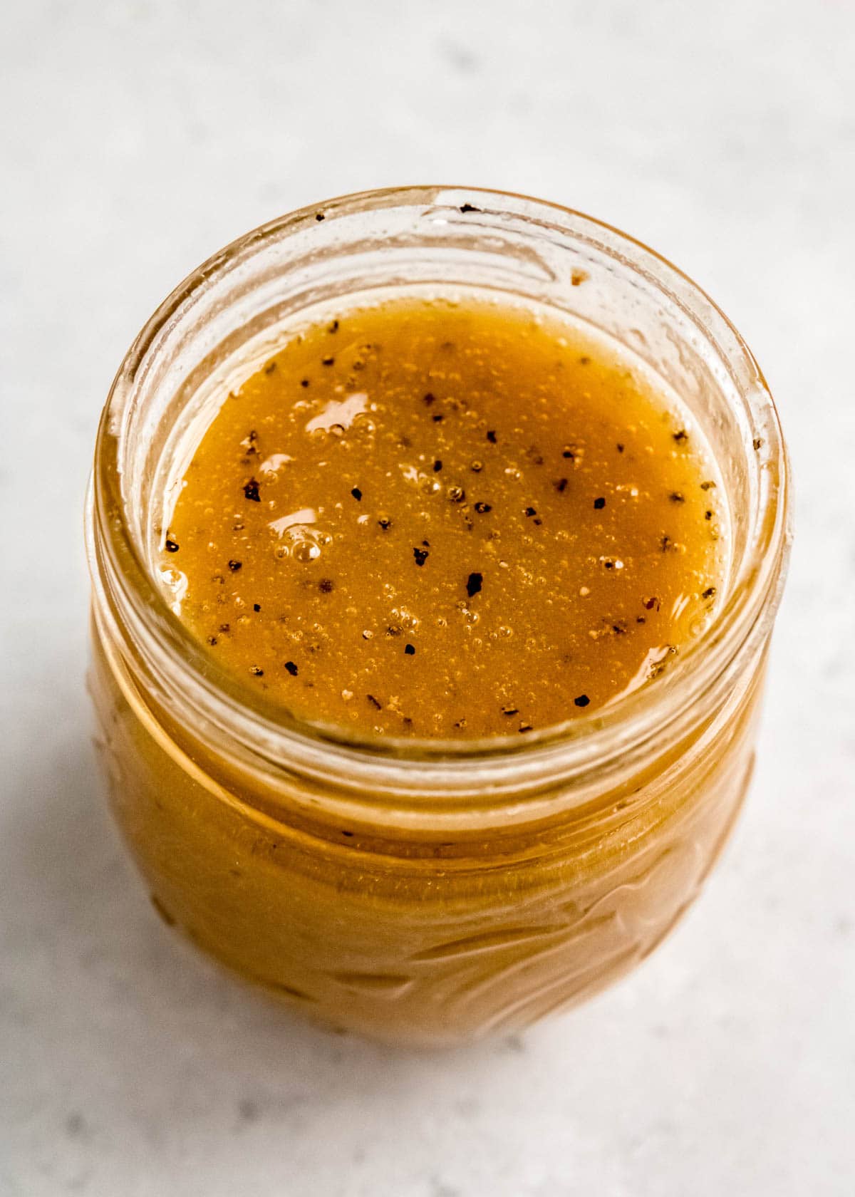 a glass jar full of delicious maple-dijon dressing