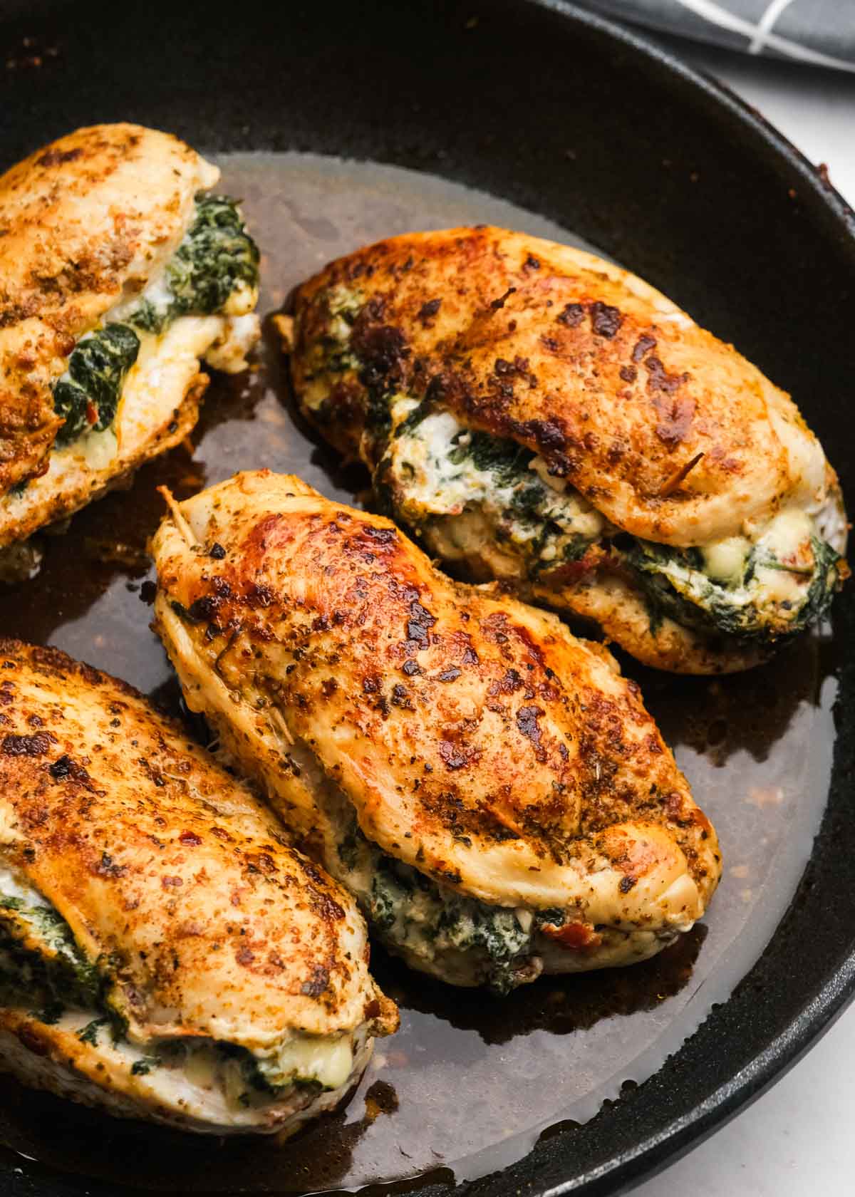 spinach and feta stuffed chicken cooked in a skillet