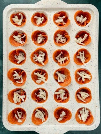 a pinch of shredded cheese added to each mini pizza snack