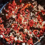 shallots, garlic, and sun-dried tomatoes sauteing in oil