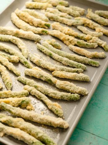 green beans coated in an almond flour parmesan mixture and placed on a baking sheet