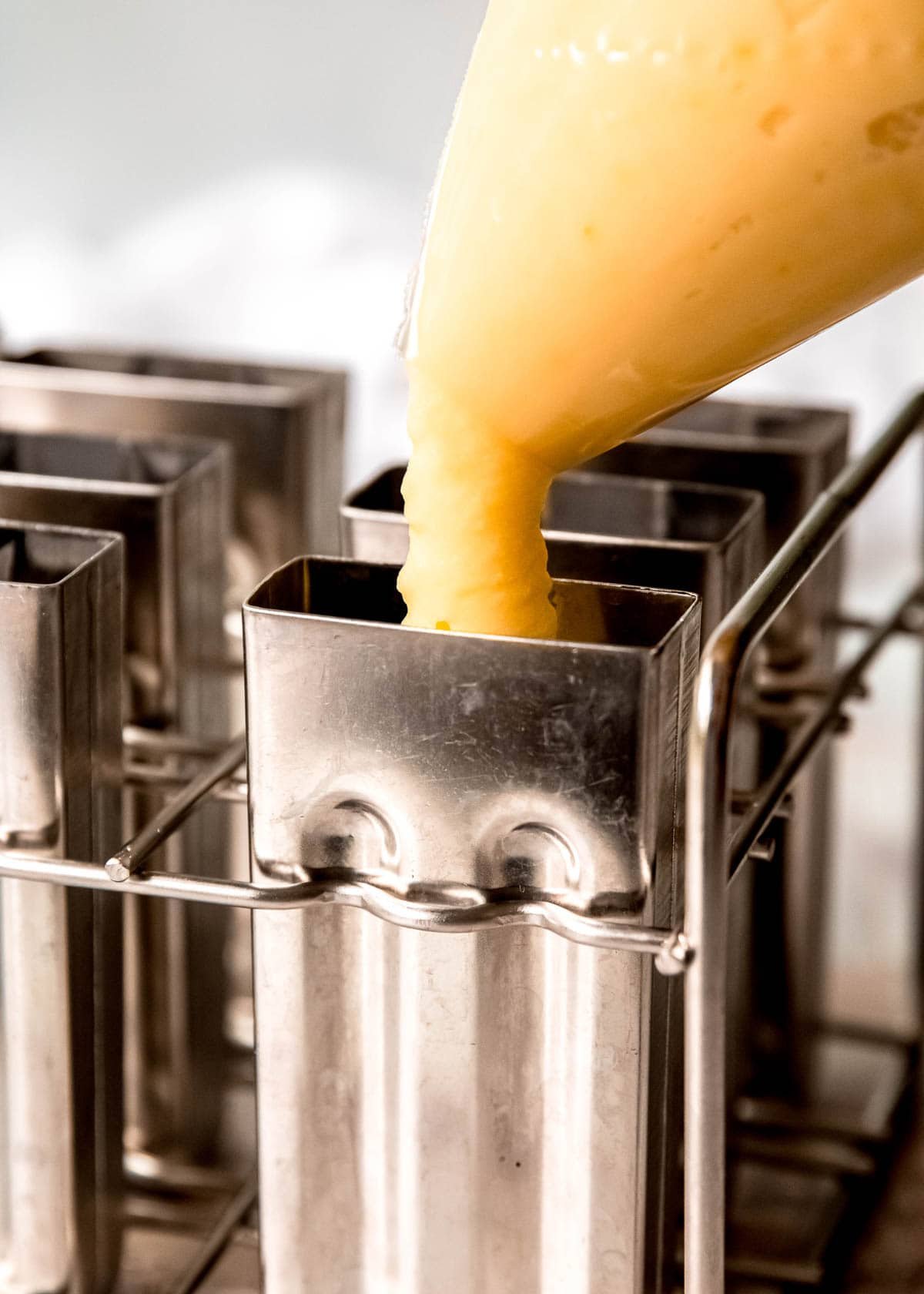 vanilla pudding being piped into a popsicle mold