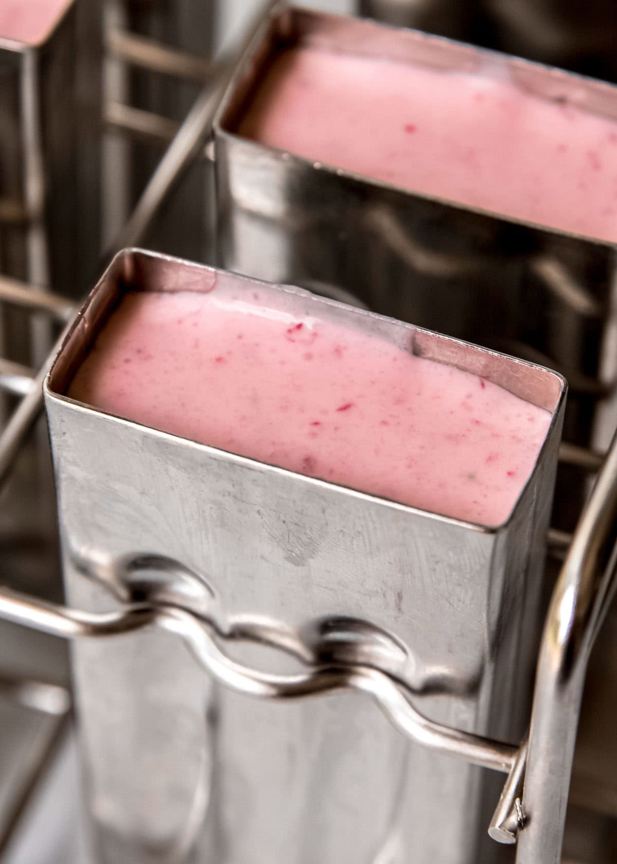 strawberry vanilla pudding mixture in a popsicle mold