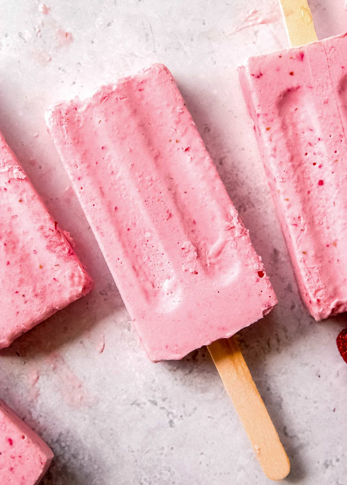 frozen strawberry pudding pops on a countertop