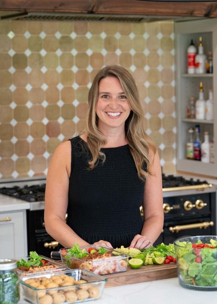 a photo of annie smiling at the camera in her kitchen
