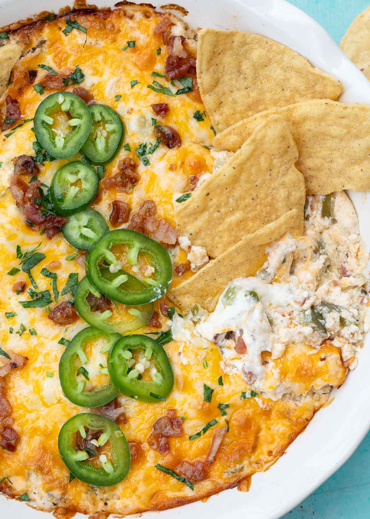 the best jalapeno popper dip topped with jalapenos, cheese, bacon, and chives and served with tortilla chips