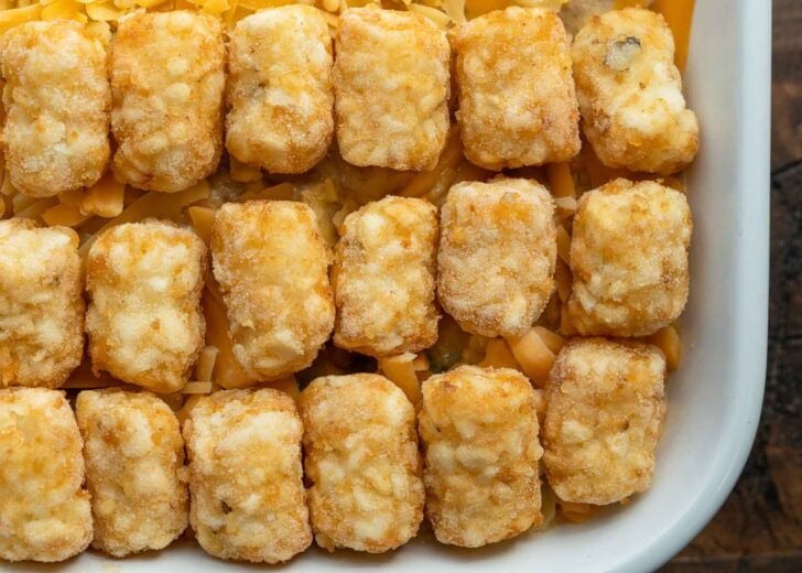 tater tots topping cheese and a creamy beef and veggie mixture for a cowboy casserole