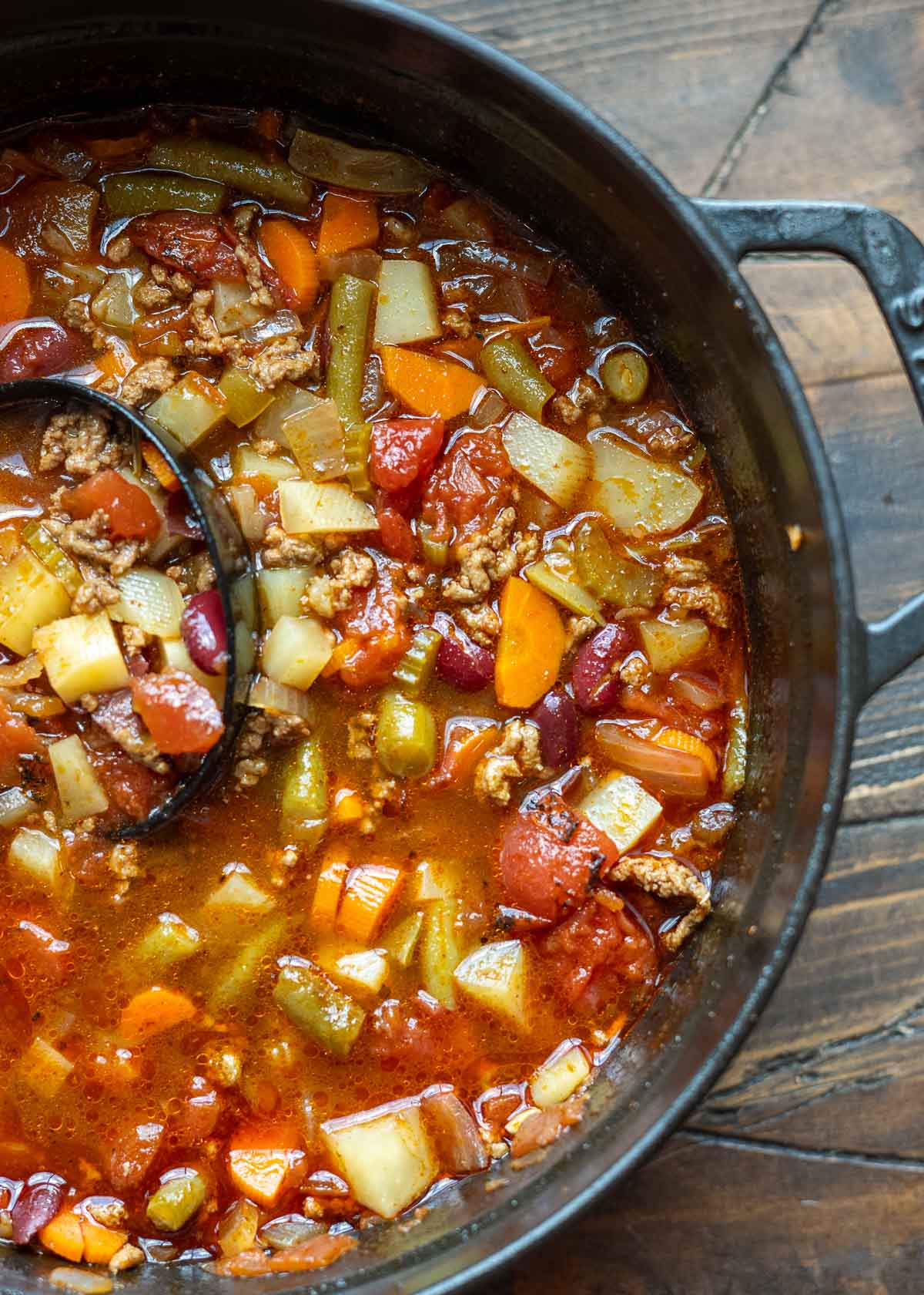 cast iron dutch oven filled with a beef and veggie filled cowboy soup