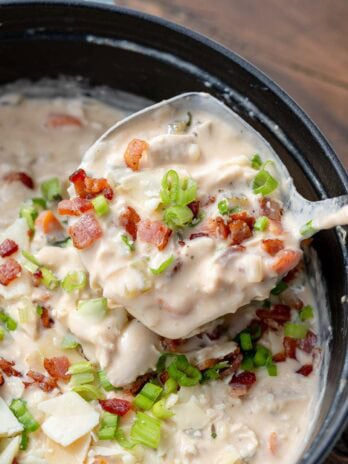 a ladle of creamy chicken soup with ranch, bacon, and green onions