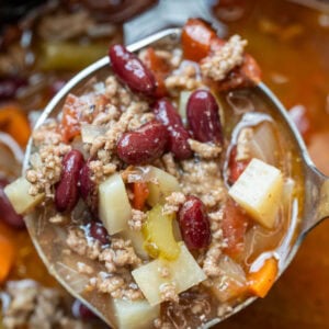a ladle in a crockpot full of cowboy soup with ground beef