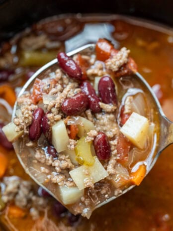 a ladle in a crockpot full of cowboy soup with ground beef