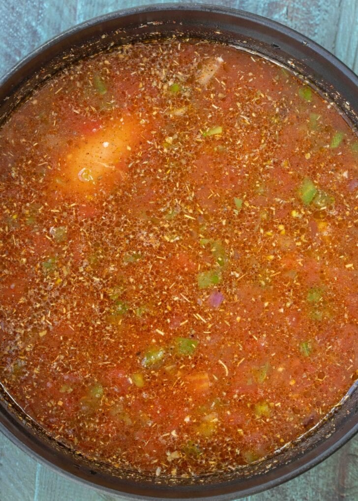 seasonings, canned tomatoes, and broth added to a pot