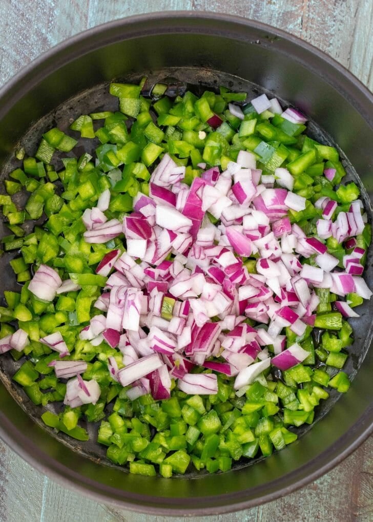 chopped bell pepper, jalapenos, and red onions in a pot