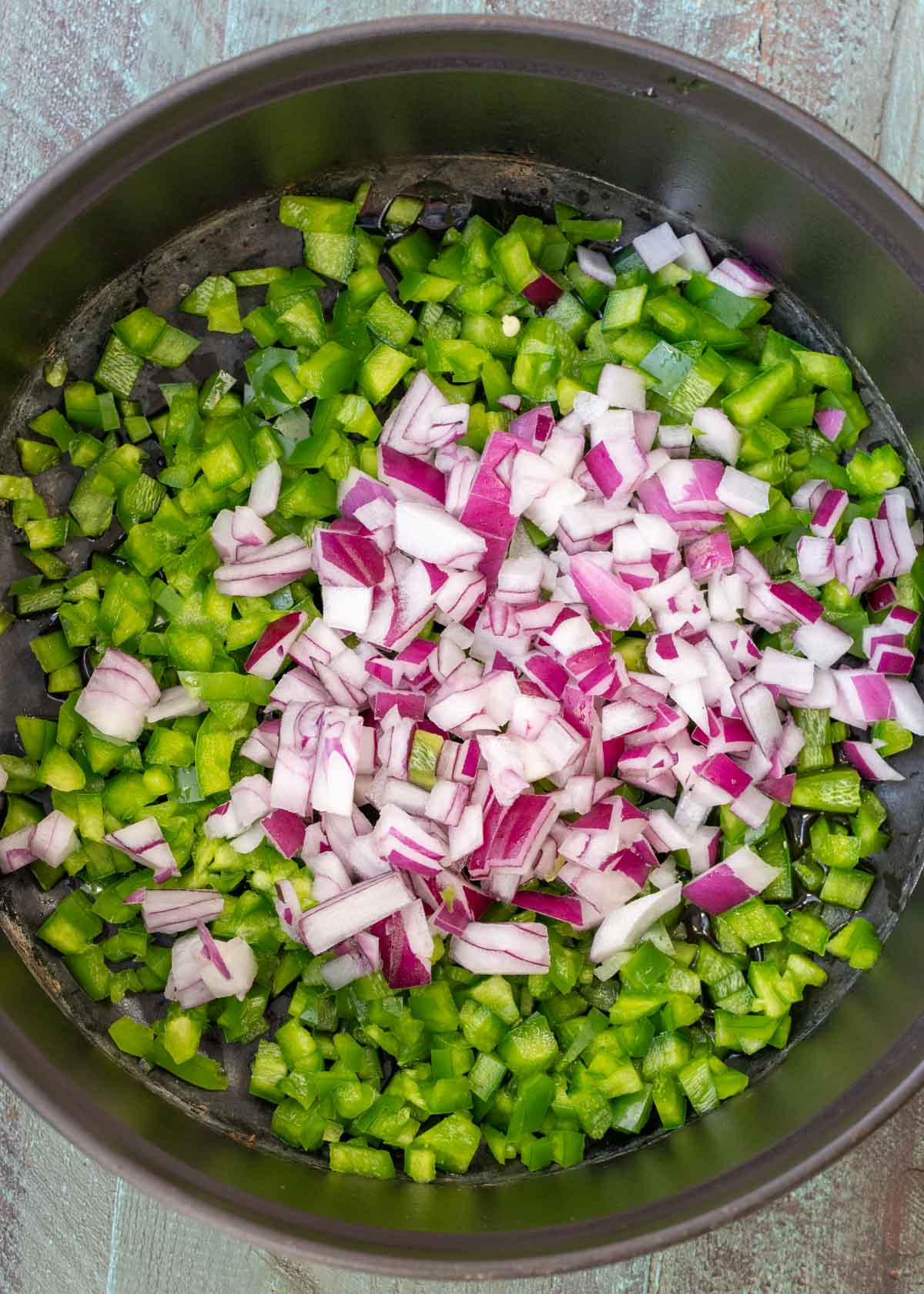 chopped bell pepper, jalapeno, and red onion in a dutch oven with olive oil