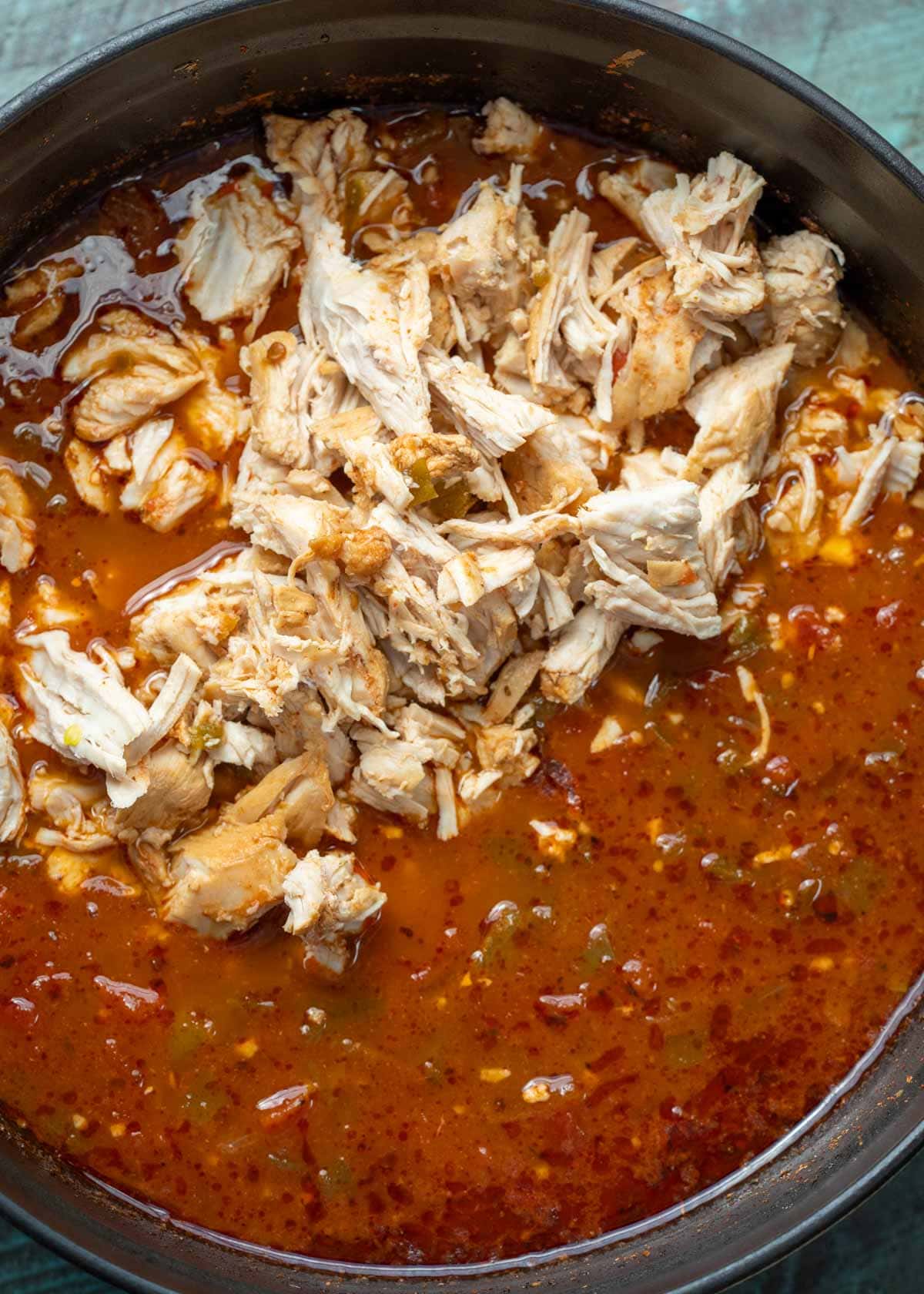 a spicy chipotle soup with shredded chicken in a pot