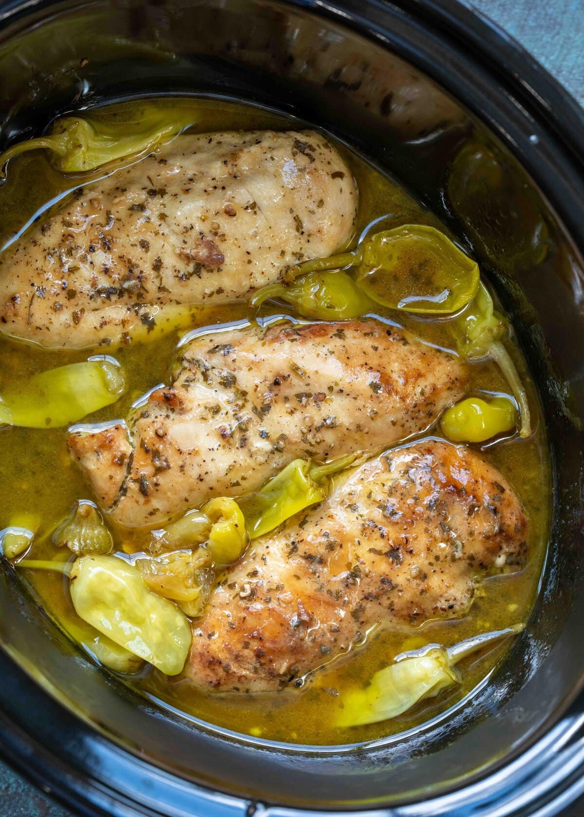 Cooked chicken breasts in a ranch and pepperoncini sauce