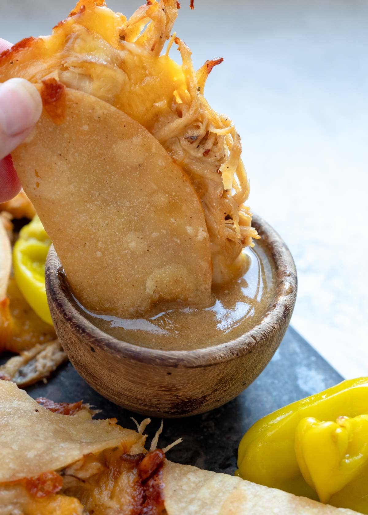 a baked taco dipped in mississippi chicken sauce