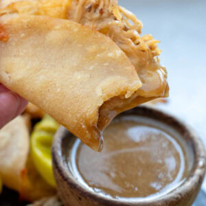 a bite taken out of a juicy baked taco with mississippi chicken sauce