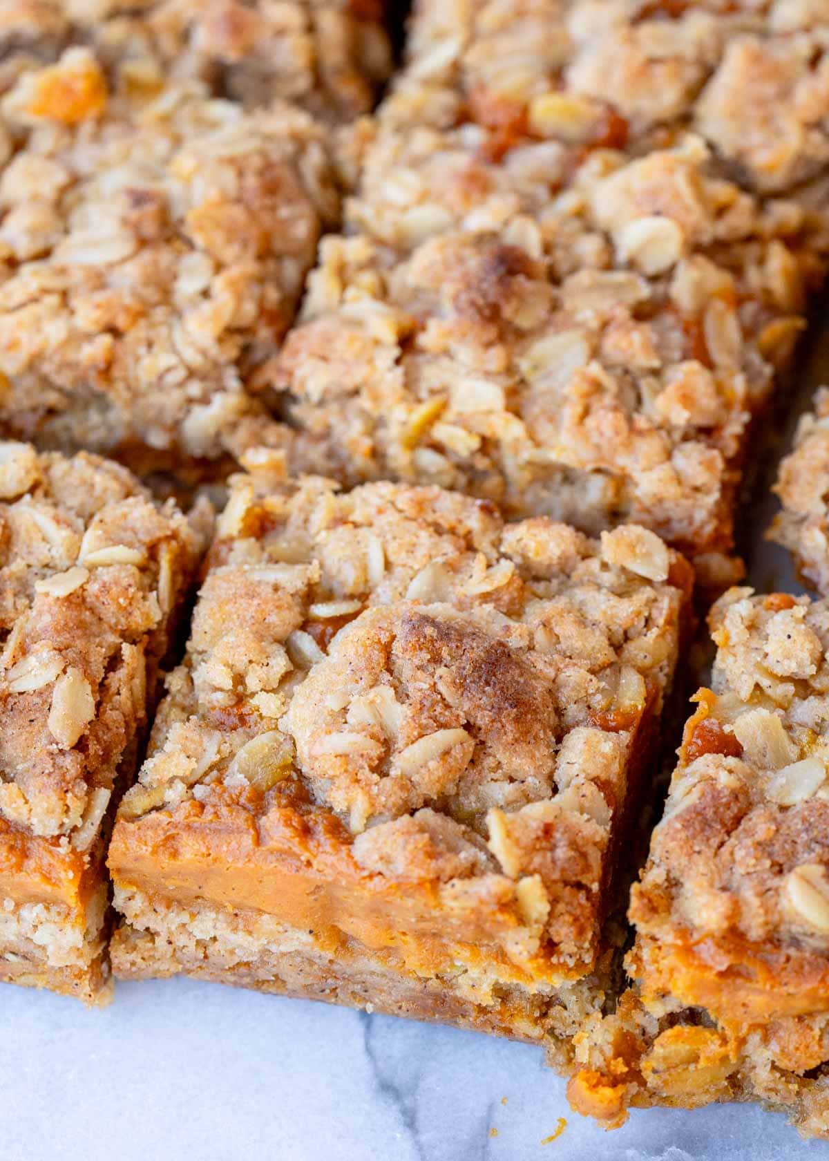 Pumpkin pie bars with an oat crumble topping, sliced into squares