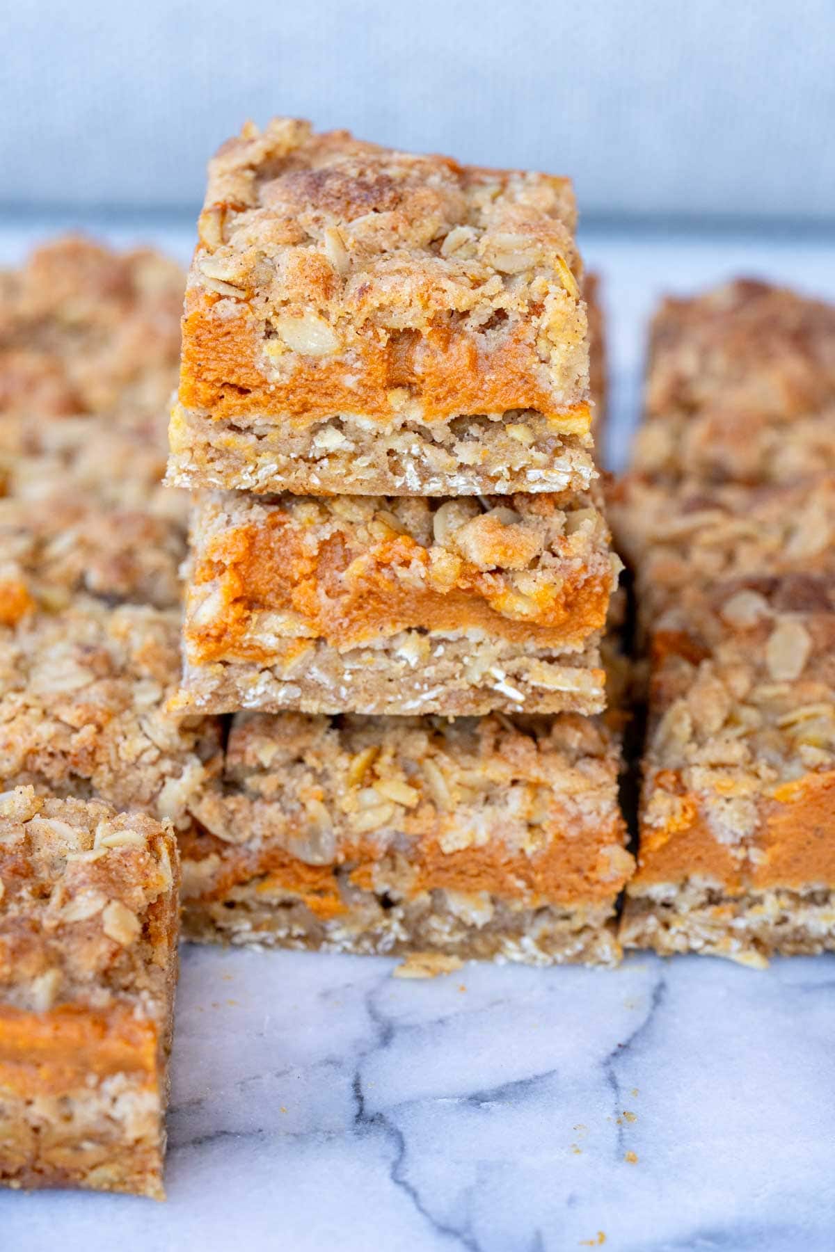 Pumpkin Bars stacked atop one another with oat crumble crust