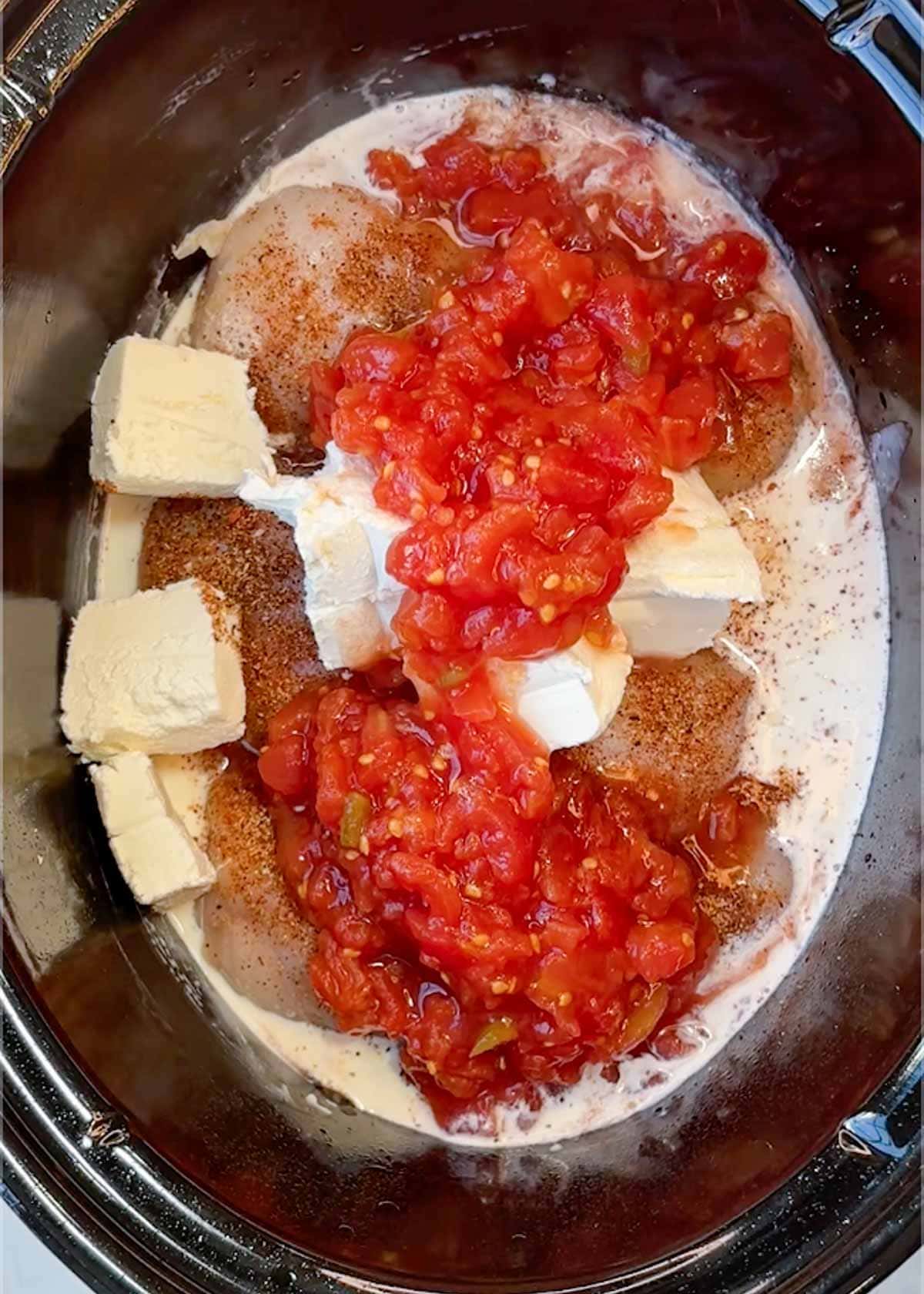cream cheese, heavy cream, and canned rotel tomatoes and chilis in a slow cooker with taco-seasoned chicken breasts