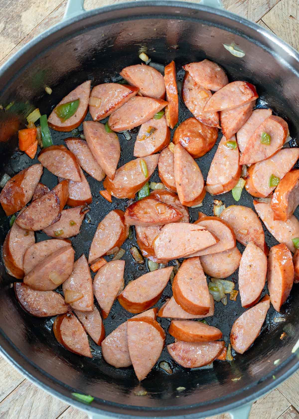 sliced andouille sausage browning in a pot