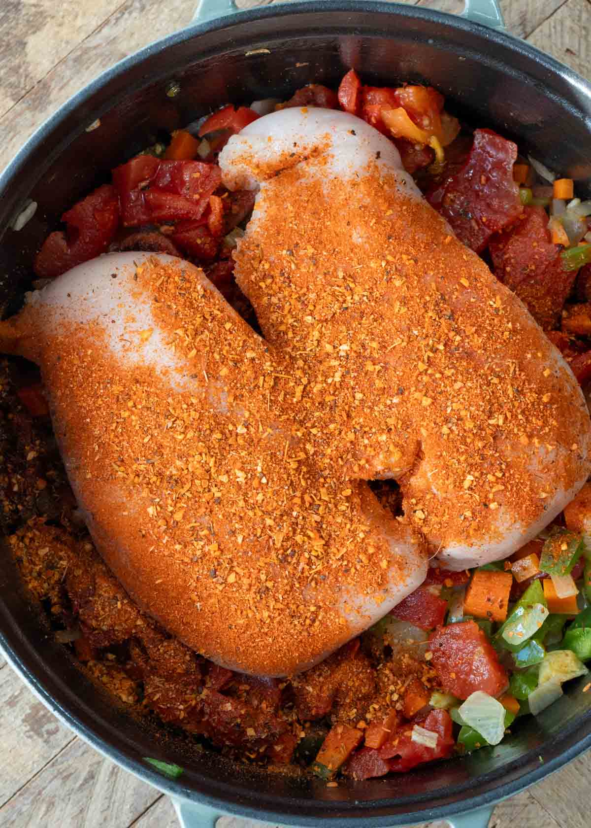 sauteed veggies, browned sausage, chicken breasts, and seasoning in a dutch oven