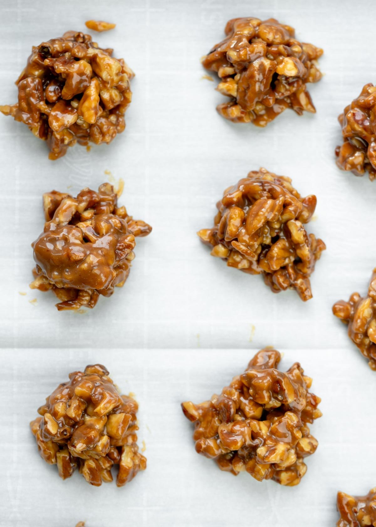 caramel nut clusters on a sheet of parchment paper