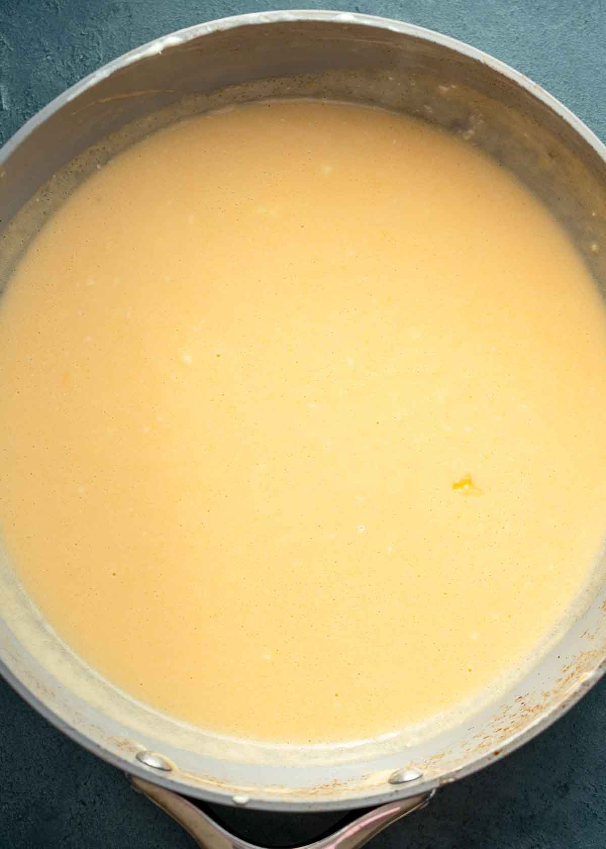 a cheesy low-carb sauce in a pan, ready for cauliflower casserole