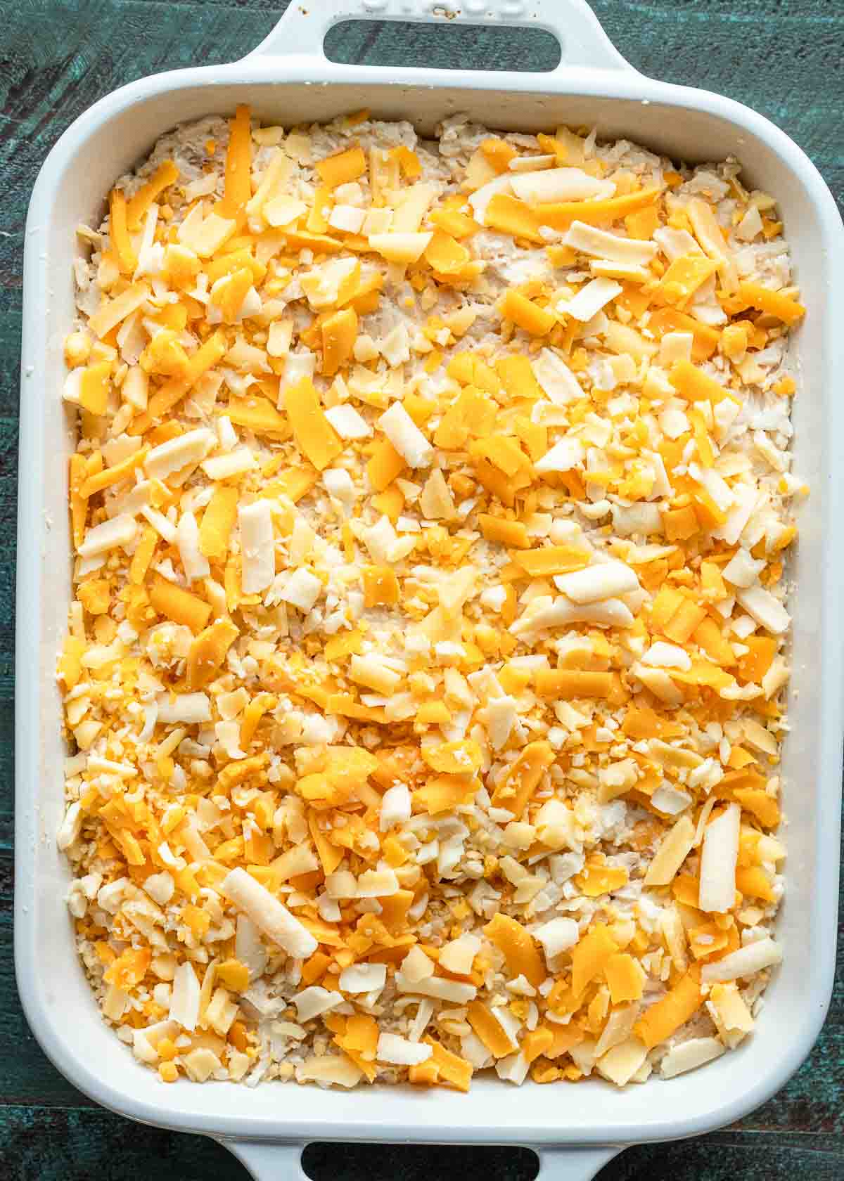 The cheesy chicken rice mixture pressed gently into a greased casserole dish and topped with cheese