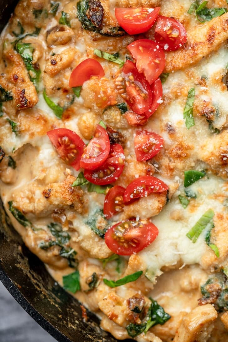 marry me chicken gnocchi in a skillet with fresh tomatoes and basil