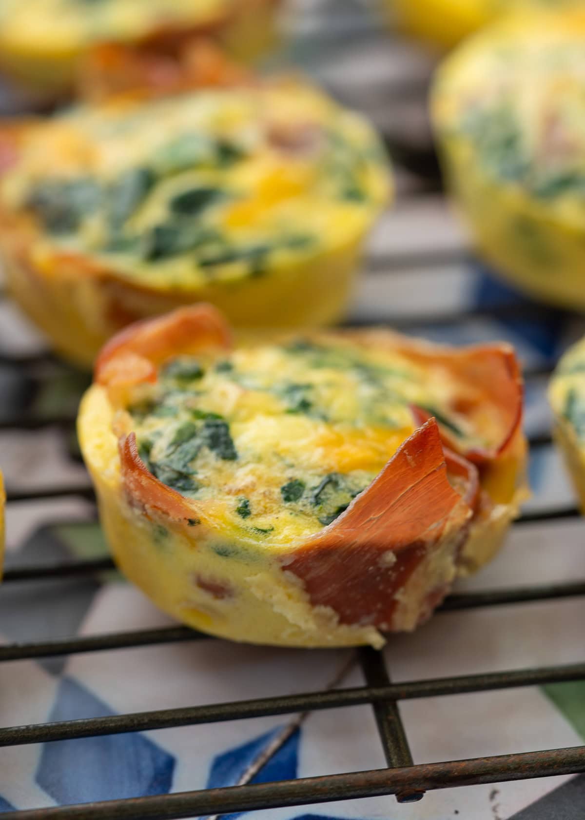 egg muffins with spinach and prosciutto on a cooling rack