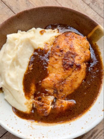 creamy mashed potatoes underneath juicy chicken and gravy