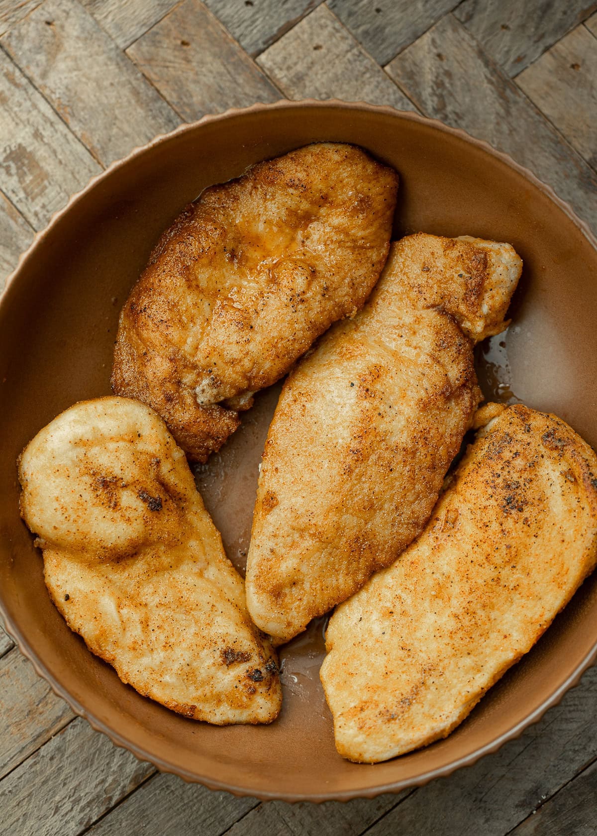 seasoned chicken cutlets in a skillet