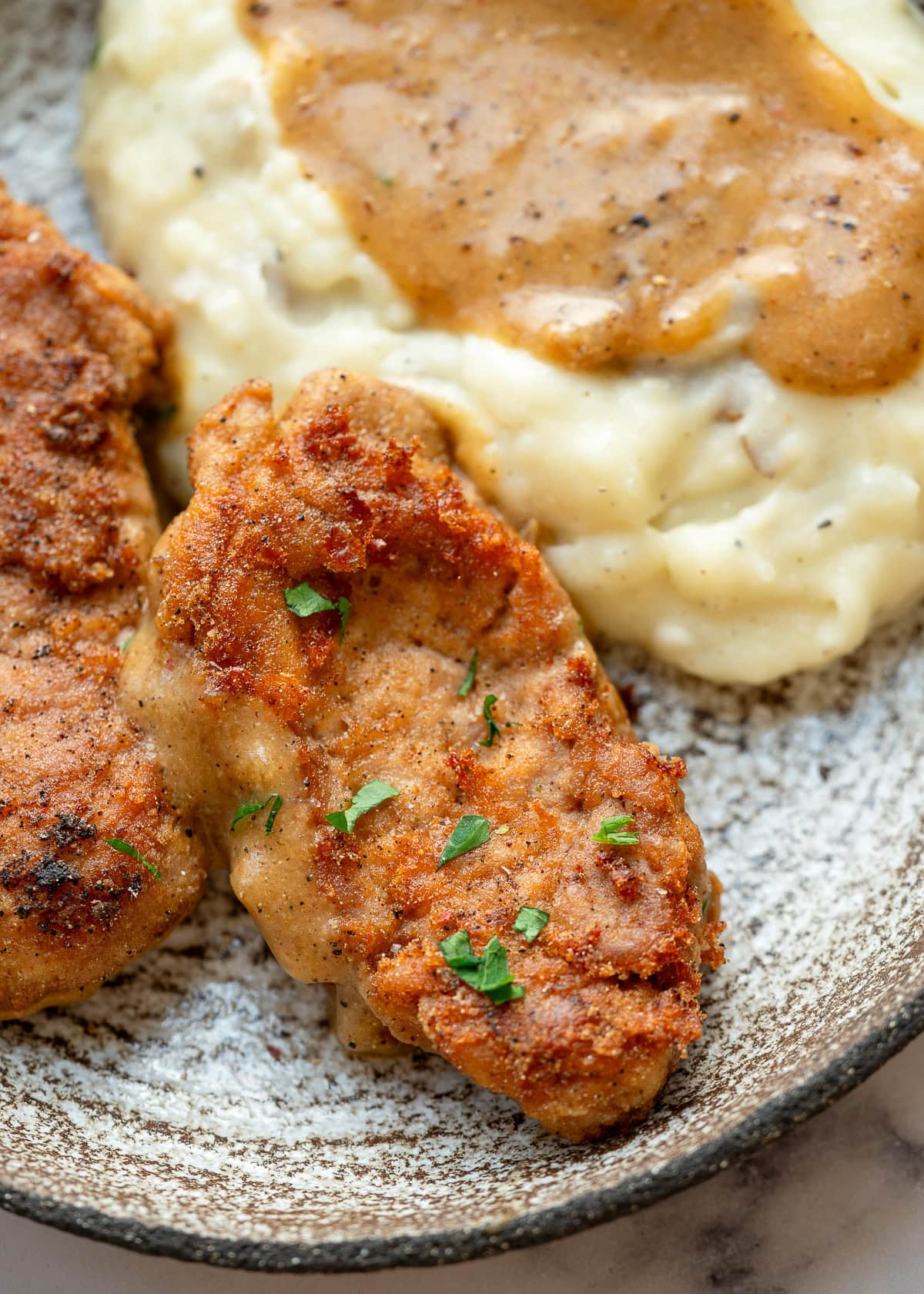 closeup of the perfect pan fried pork tenderloin with potatoes and gravy